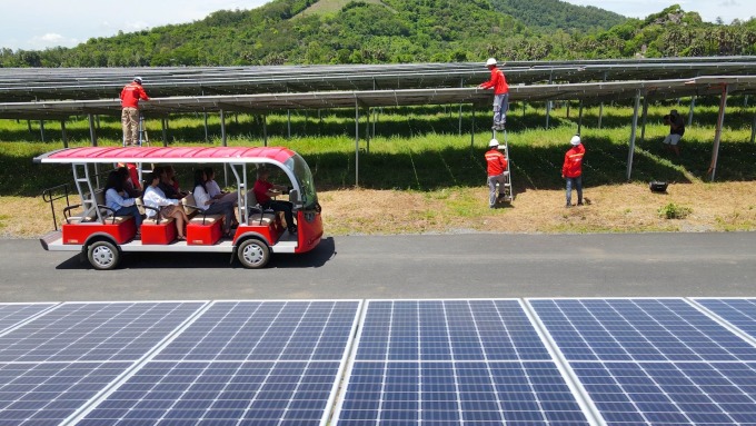 Du khách ngồi xe điện tham quan khu vực cánh đồng điện mặt trời ngay dưới chân núi Cấm của Sao Mai Group. Ảnh: Sao Mai Group