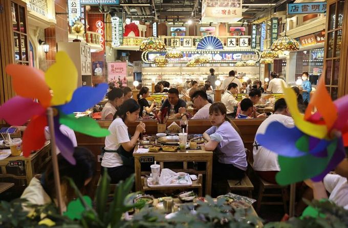 Thực khách ăn tối tại khu vực ăn uống ở một trung tâm mua sắm tại Bắc Kinh. Ảnh: Reuters